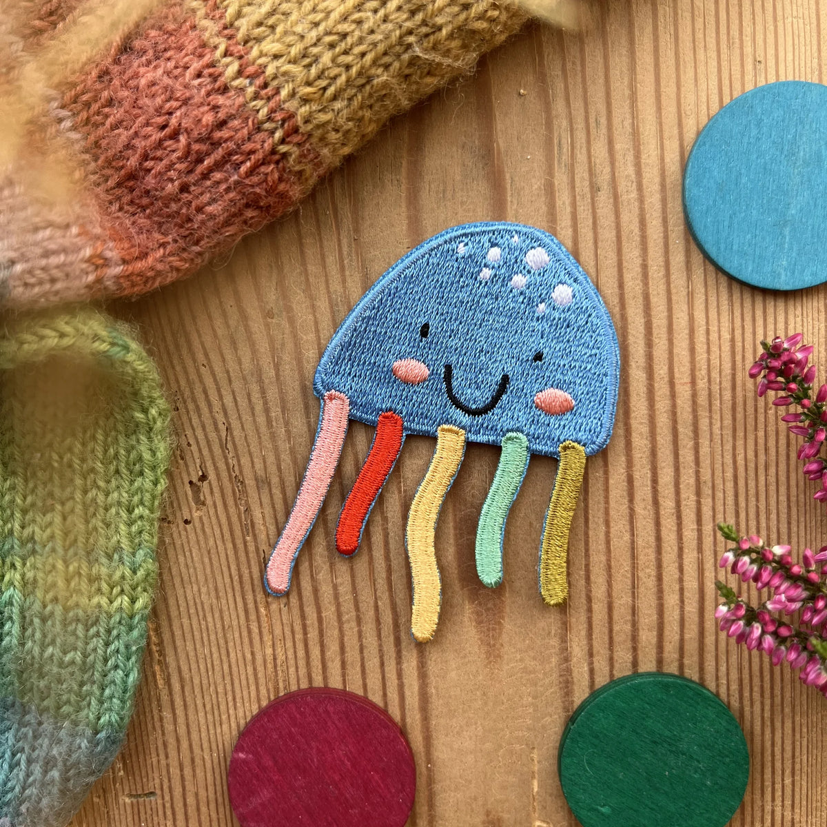 Hannahs Firlefanz Patch blaue Qualle mit bunten Tentakeln, gestickt, auf Holz zwischen bunten Holzscheiben
