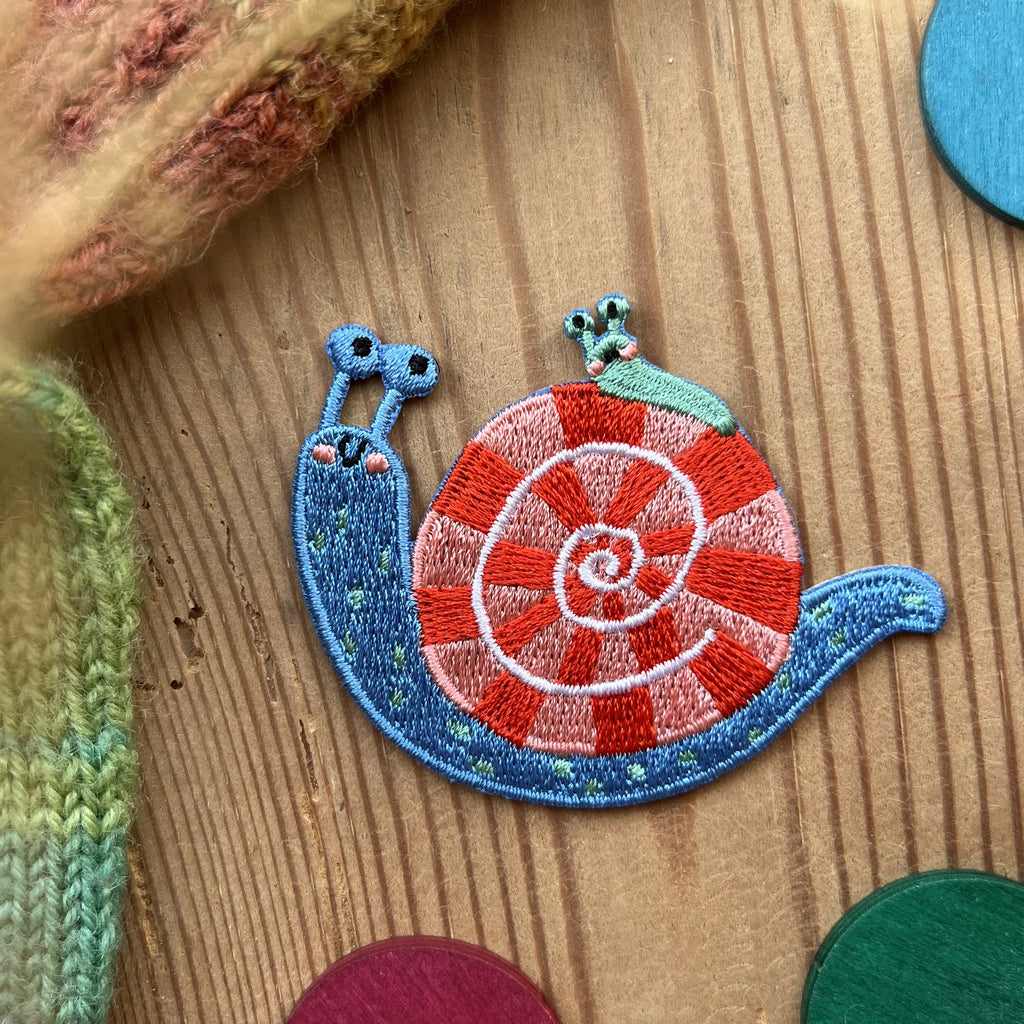 Hannahs Firlefanz Patch Schnecke mit rot-weißem Haus, gestickt, auf Holz zwischen bunten Holzscheiben