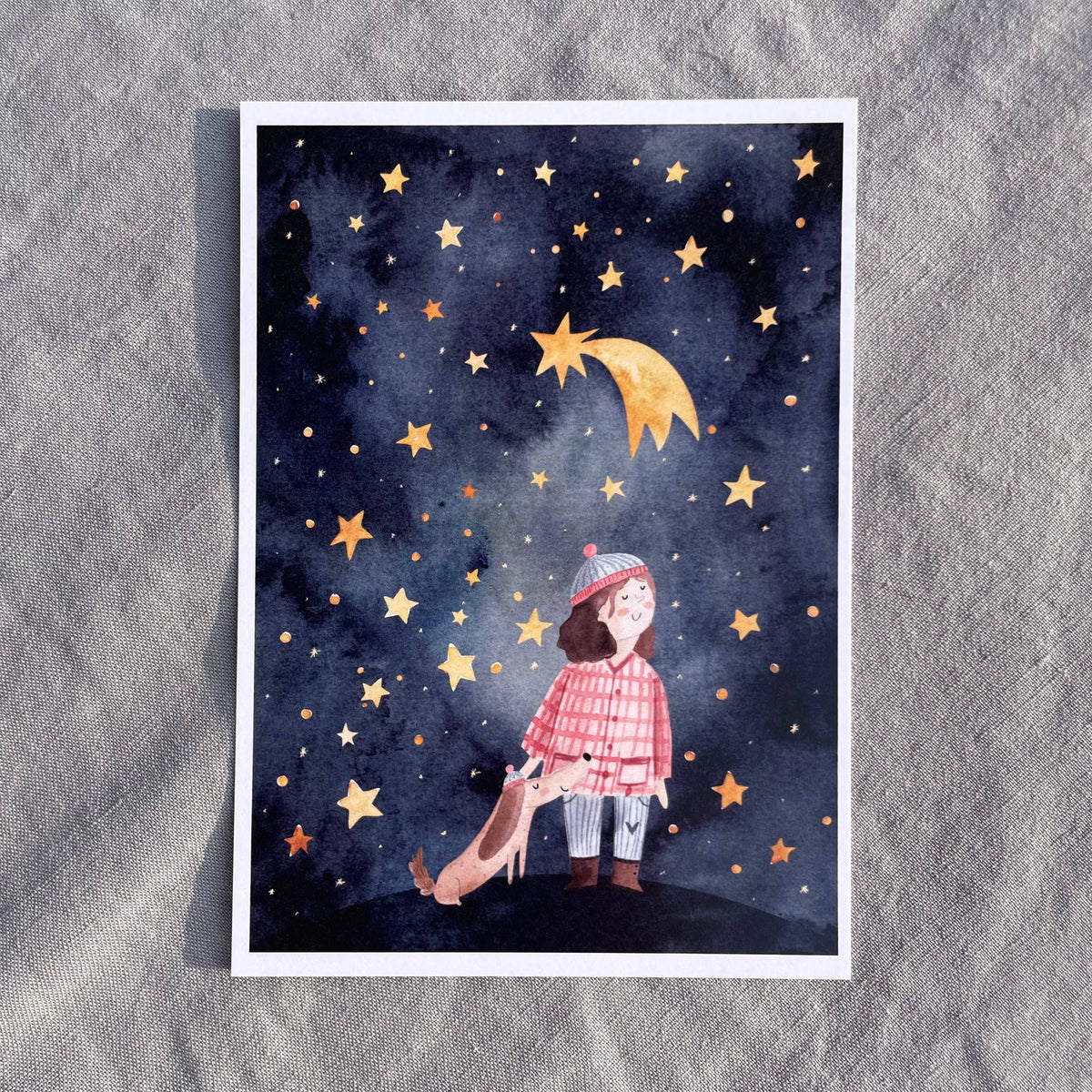 Postkarte Sternenhimmel von Hannahs Firlefanz A6, Kind mit Mütze und Hund unter dem Sternenhimmel mit Sternschnuppe