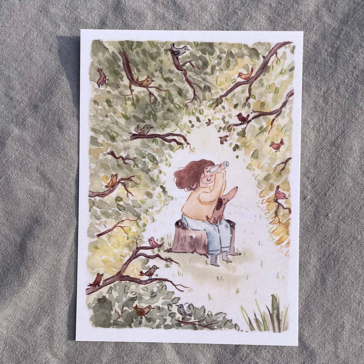 Postkarte Vogelbeobachtung von Hannahs Firlefanz A6, Person mit Fernglas und Hund auf einem Baumstumpf, in den Ästen sitzen Vögel