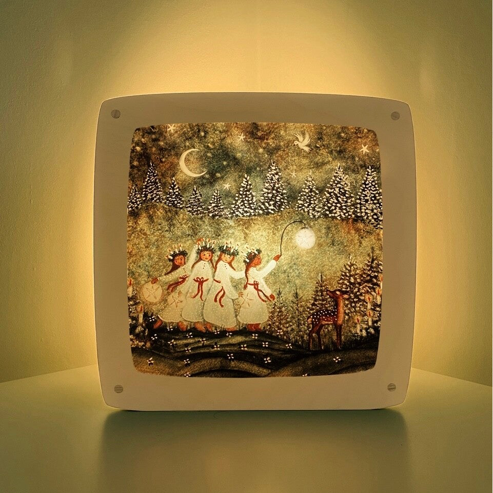 Motiv Advent von Bijdehansje für die magische Lampe: Kinder in weißen Kleidern mit Kerzenkränzen im nächtlichen Wald, daneben ein Reh