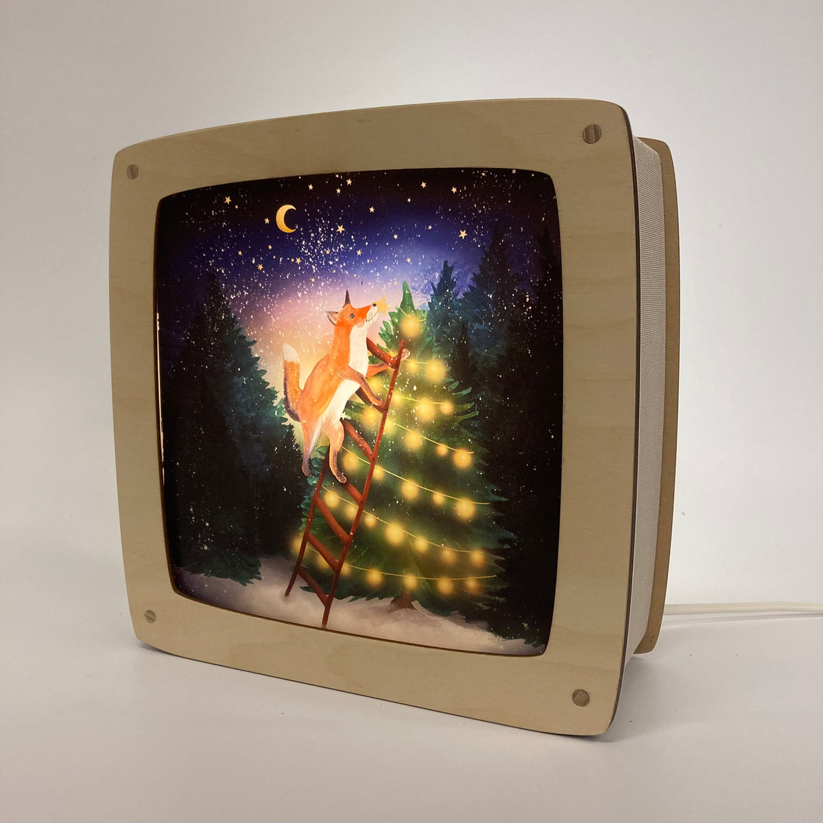 Motiv Baum schmücken von Lotte Drouen für die magische Lampe: Fuchs auf einer Leiter schmückt einen leuchtenden Tannenbaum in der verschneiten Nacht