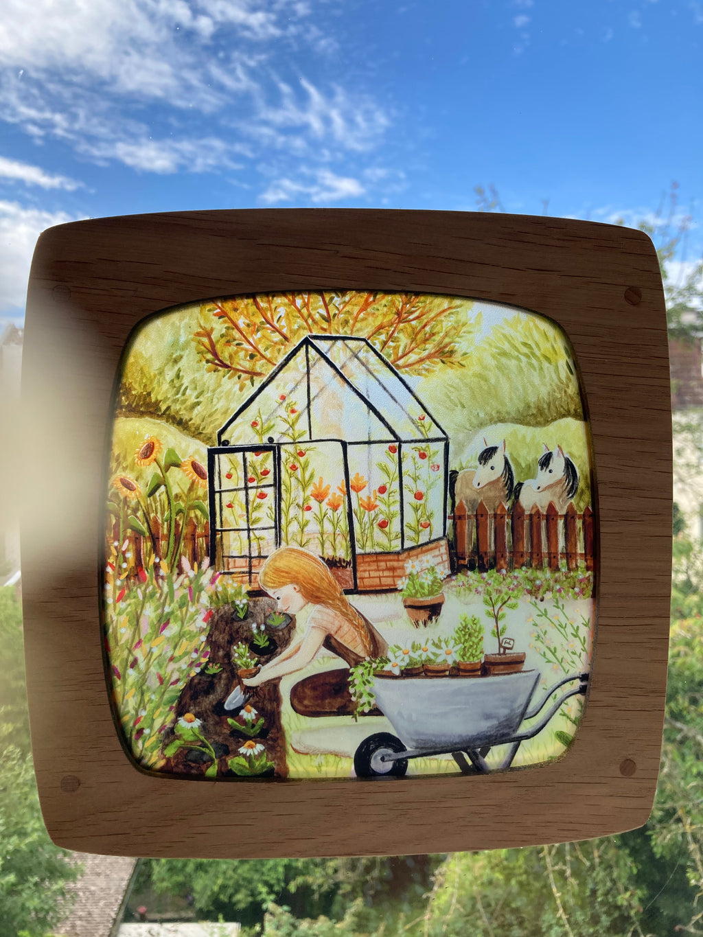 Motiv Gärtnern von Esther Bennink für die magische Lampe: Gartenarbeit mit Schubkarre vor einem Gewächshaus, ringsum Blumen und Tiere, Ansicht 2