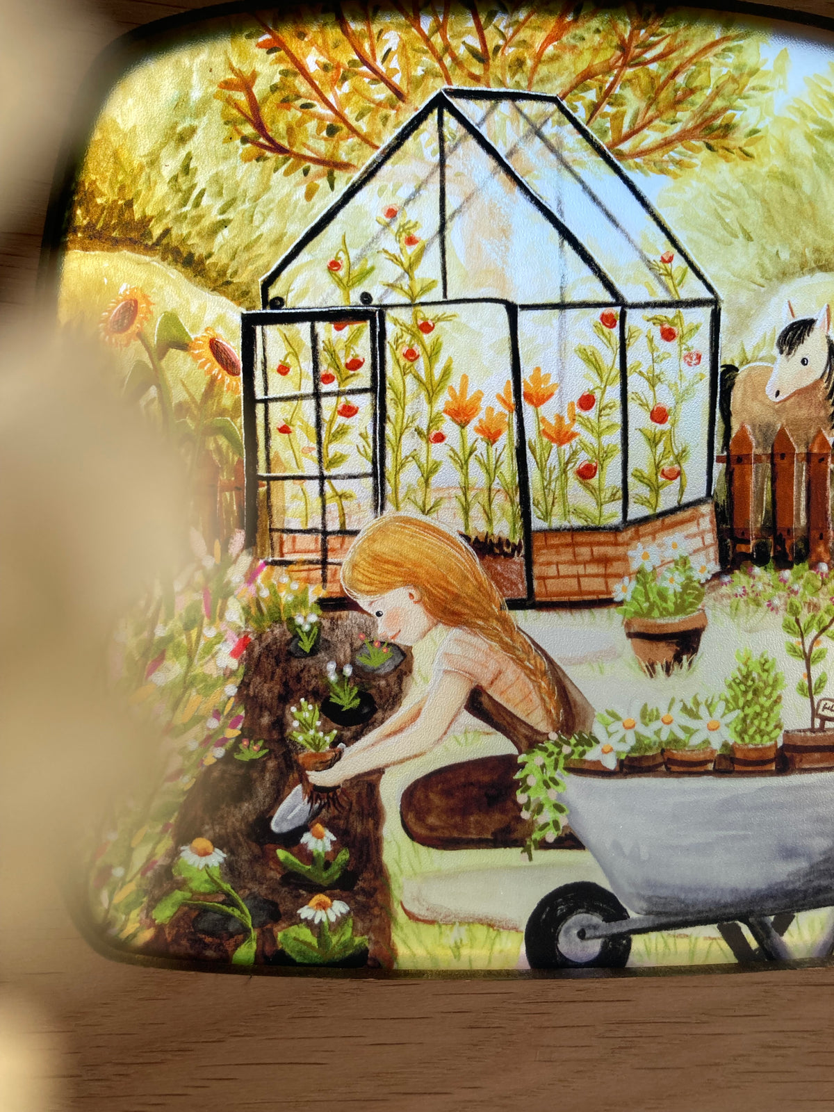 Motiv Gärtnern von Esther Bennink für die magische Lampe: Gartenarbeit mit Schubkarre vor einem Gewächshaus, ringsum Blumen und Tiere, Ansicht 5