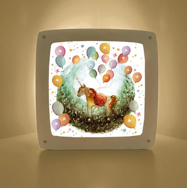 Motiv Hip hip hurra von Bijdehansje für die magische Lampe: Einhorn auf einer Blumenwiese umgeben von bunten Luftballons