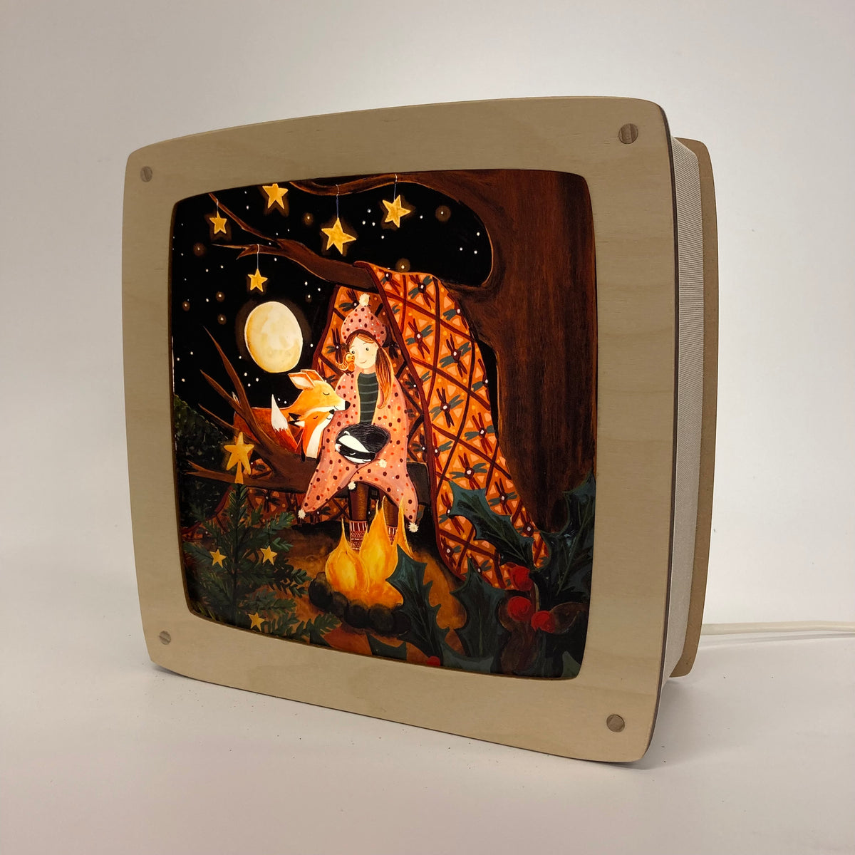 Motiv Weihnachten im Wald von Esther Bennink für die magische Lampe: In eine Decke gehüllte Gestalt am Lagerfeuer im Wald unter Mond und Sternen