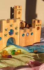 Bauspiel Holzburg Kleines Märchenschloss aus Erlenholz mit Funkelsteinen, zusammen mit Lichtbauwürfeln auf Spieltüchern, Foto