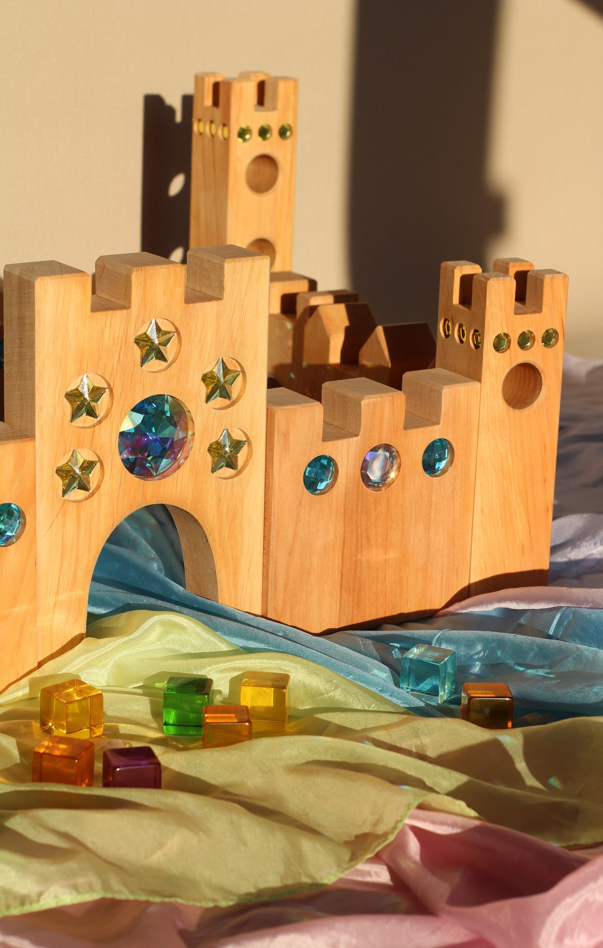 Bauspiel Holzburg Kleines Märchenschloss aus Erlenholz mit Funkelsteinen, zusammen mit Lichtbauwürfeln auf Spieltüchern, Foto