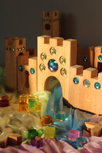 Bauspiel Holzburg Kleines Märchenschloss aus Erlenholz mit Funkelsteinen, zusammen mit Lichtbauwürfeln auf Spieltüchern, Foto