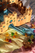 Bauspiel Holzburg Kleines Märchenschloss aus Erlenholz mit Funkelsteinen, zusammen mit Lichtbauwürfeln auf Spieltüchern, Foto