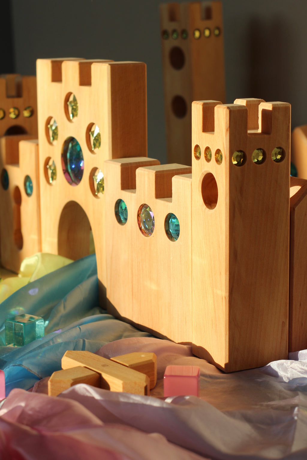 Bauspiel Holzburg Kleines Märchenschloss aus Erlenholz mit Funkelsteinen, zusammen mit Lichtbauwürfeln auf Spieltüchern, Foto