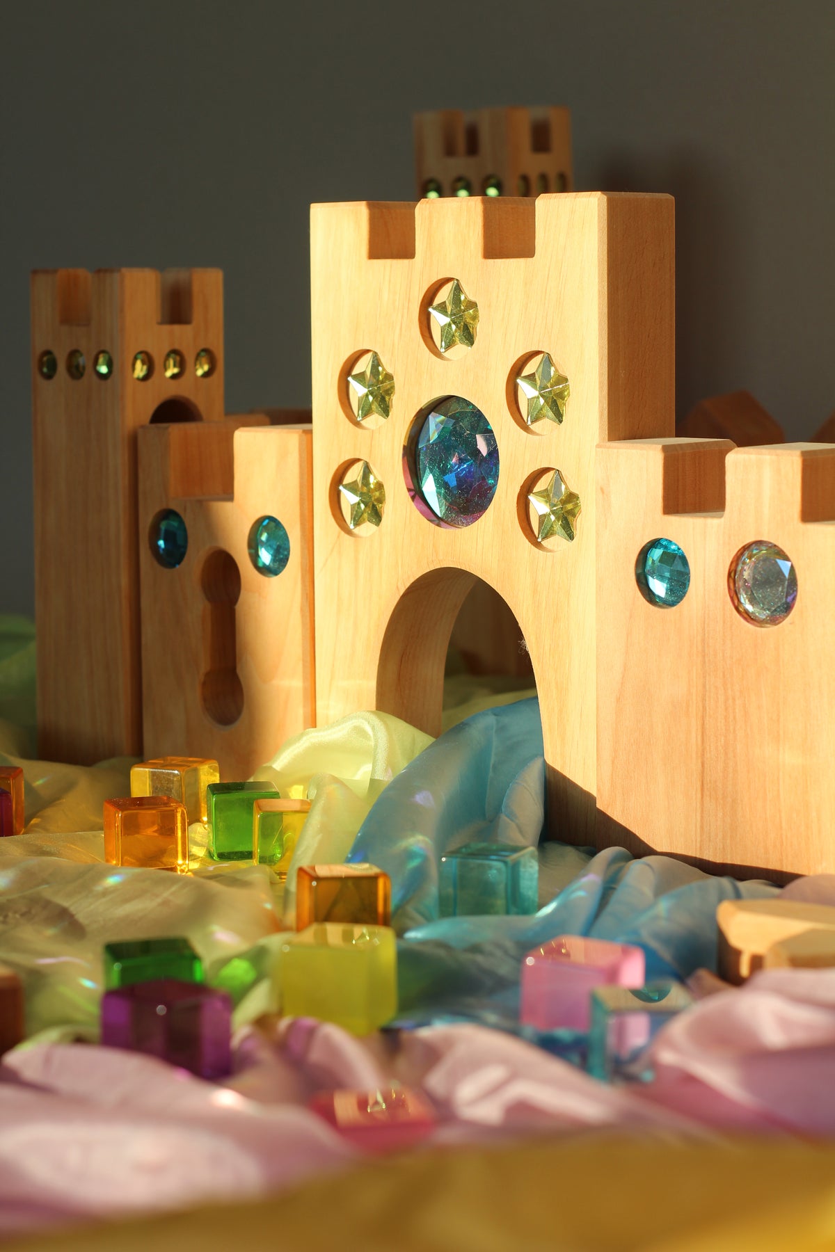 Bauspiel Holzburg Kleines Märchenschloss aus Erlenholz mit Funkelsteinen, zusammen mit Lichtbauwürfeln auf Spieltüchern, Foto