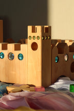 Bauspiel Holzburg Kleines Märchenschloss aus Erlenholz mit Funkelsteinen, zusammen mit Lichtbauwürfeln auf Spieltüchern, Foto