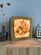 Motiv Ein Wintermärchen von Iris Esther in der magischen Lampe aus Holz auf einer Kommode, Foto