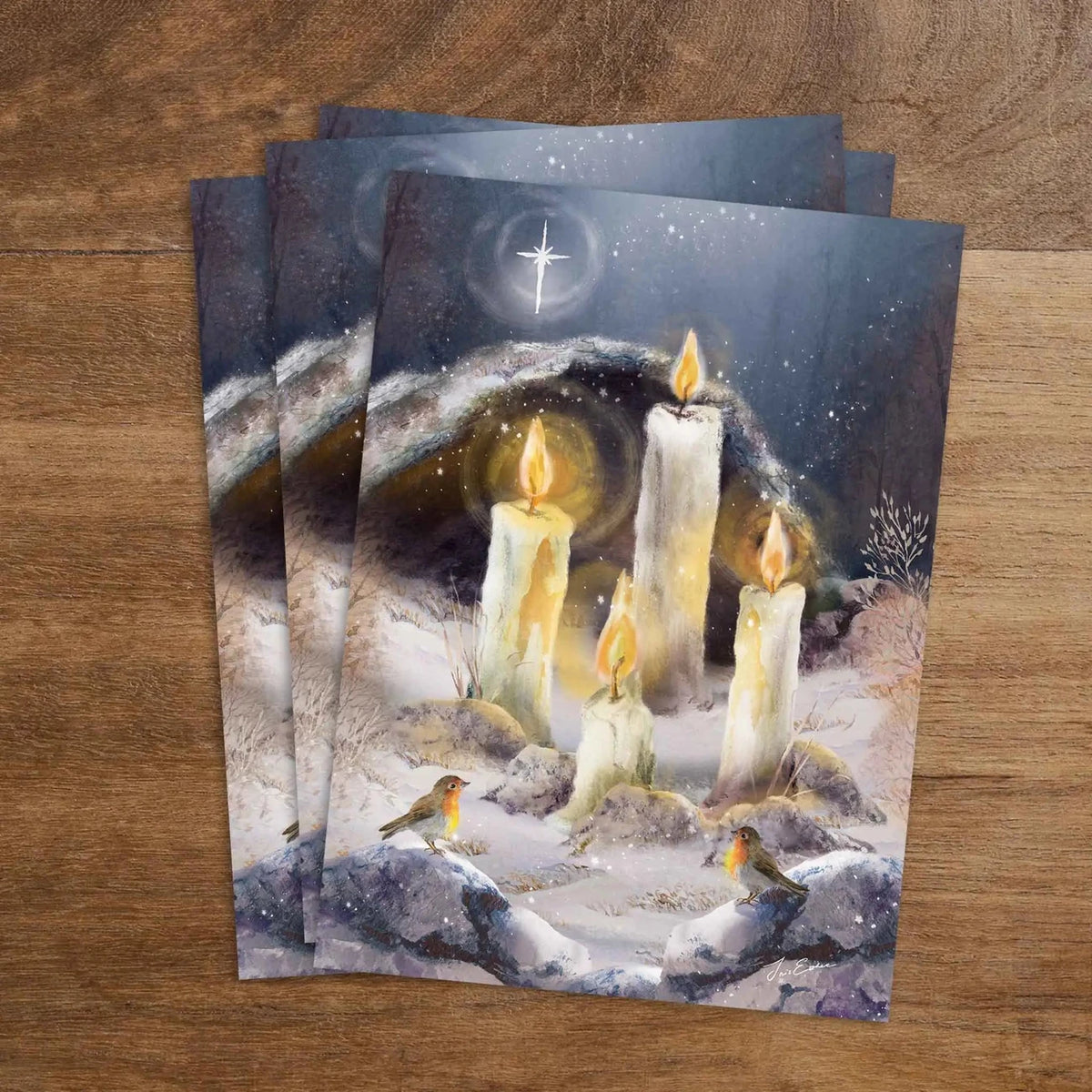 Postkarte Adventslichter von Iris Esther A6: vier Kerzen brennen im verschneiten Wald unter einem hellen Stern, Rotkehlchen sitzen dabei