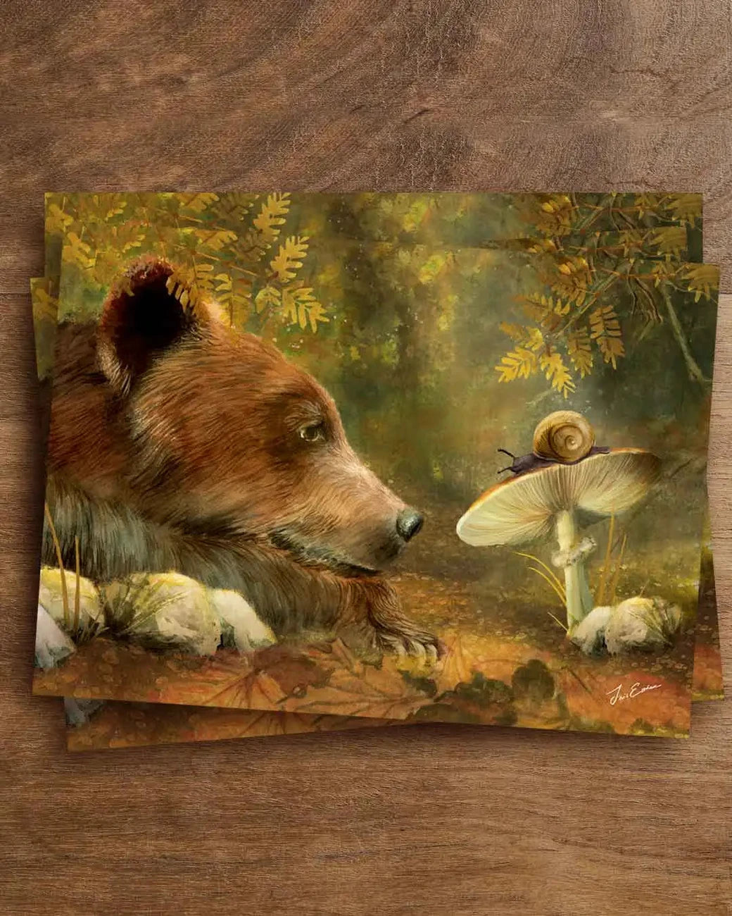 Postkarte Bär mit Schnecke von Iris Esther A6: ein Bär senkt im Herbstwald den Kopf und betrachtet ganz nah eine kleine Schnecke im Laub