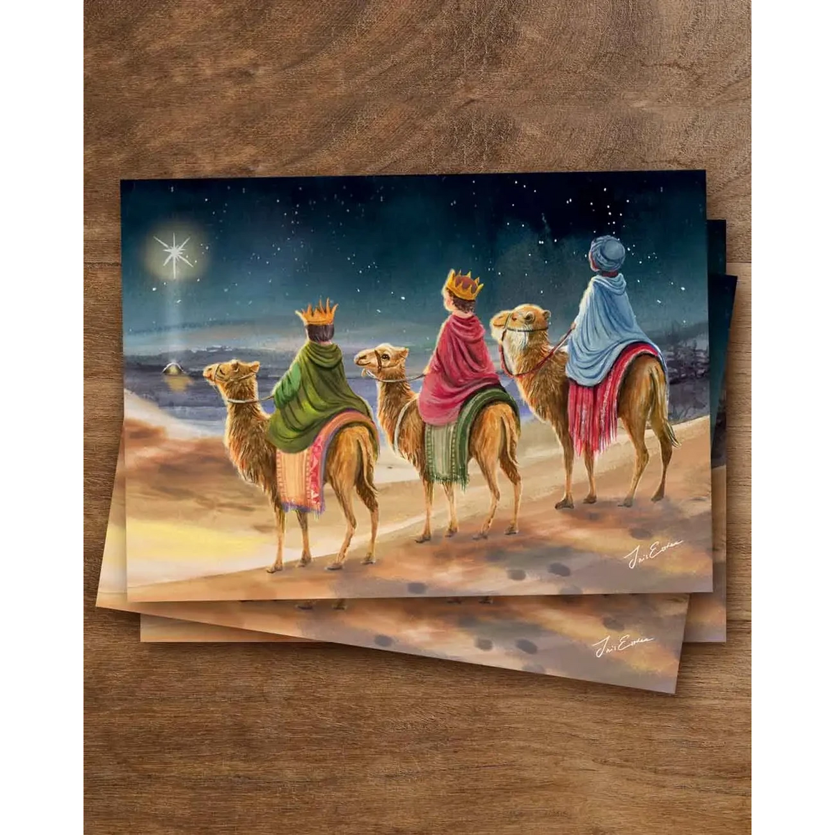 Postkarte Drei Könige von Iris Esther A6: drei Kinder mit Kronen reiten auf Kamelen unter dem Winterhimmel einem Stern entgegen