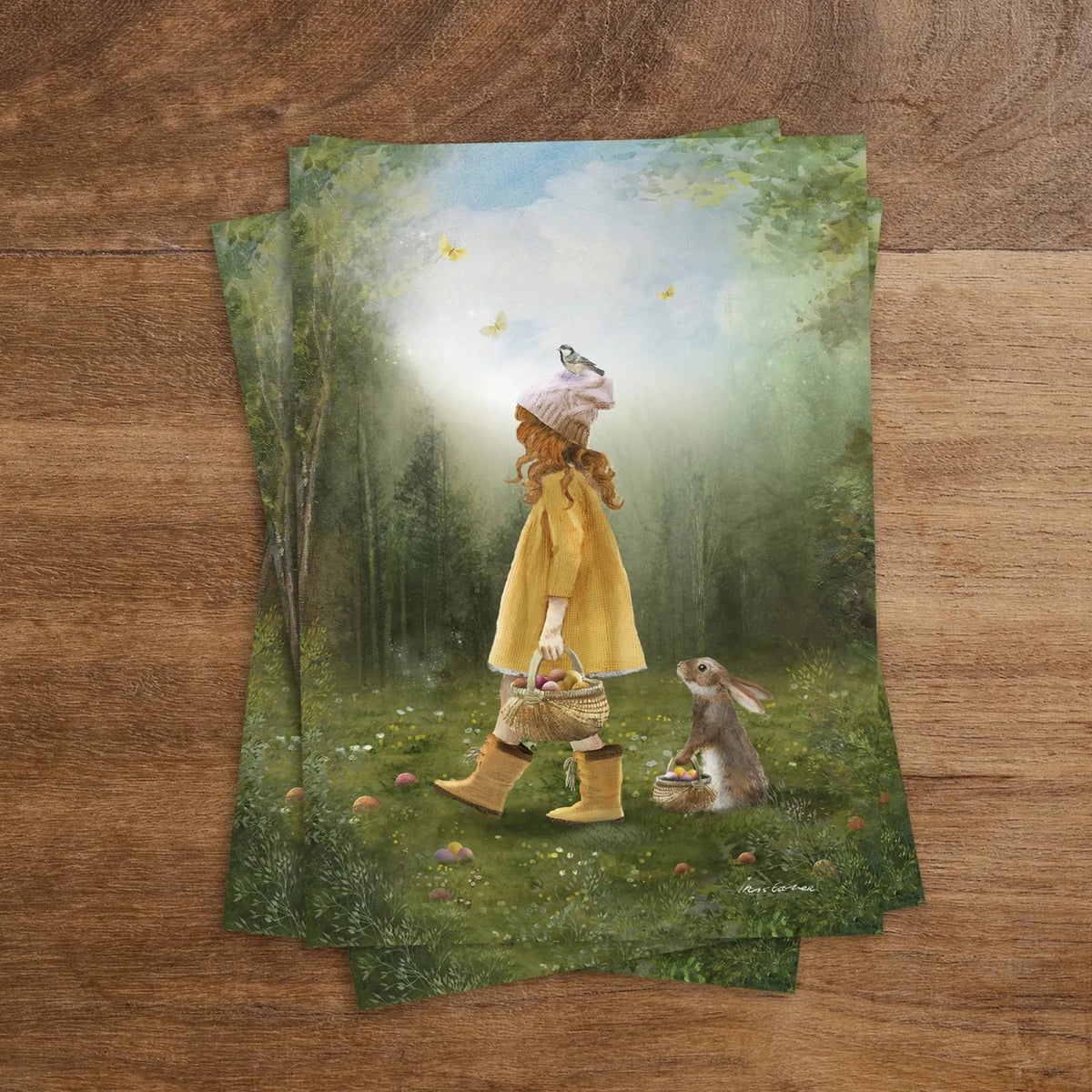 Postkarte Eiersuche von Iris Esther A6: ein kleines Mädchen mit Korb sucht im Frühlingswald Ostereier, ein Vogel sitzt auf seinem Hut