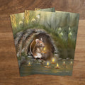 Postkarte Kerzenmaus von Iris Esther A6: eine kleine Maus setzt eine brennende Kerze aufs Wasser, ringsum blühen die ersten Schneeglöckchen