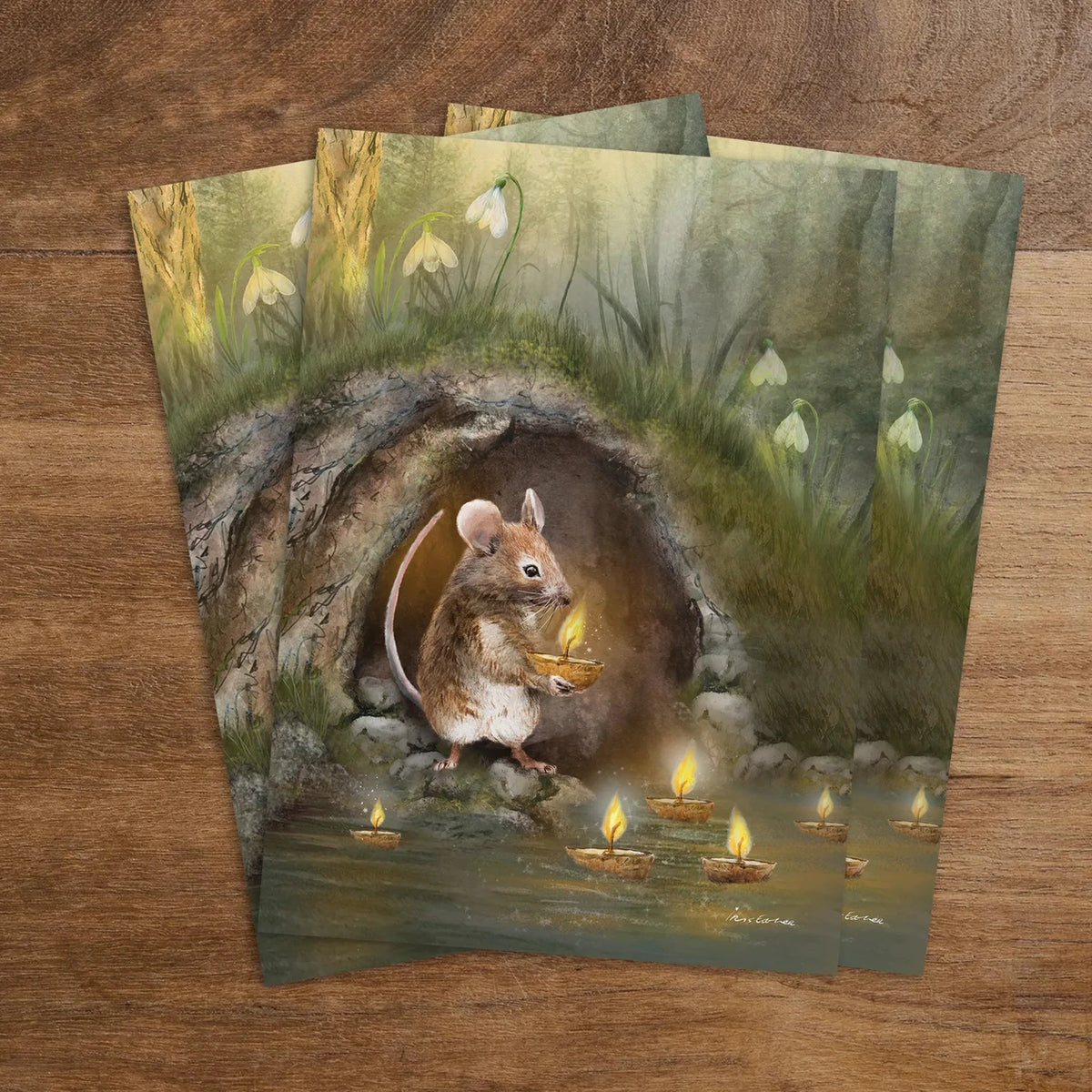 Postkarte Kerzenmaus von Iris Esther A6: eine kleine Maus setzt eine brennende Kerze aufs Wasser, ringsum blühen die ersten Schneeglöckchen