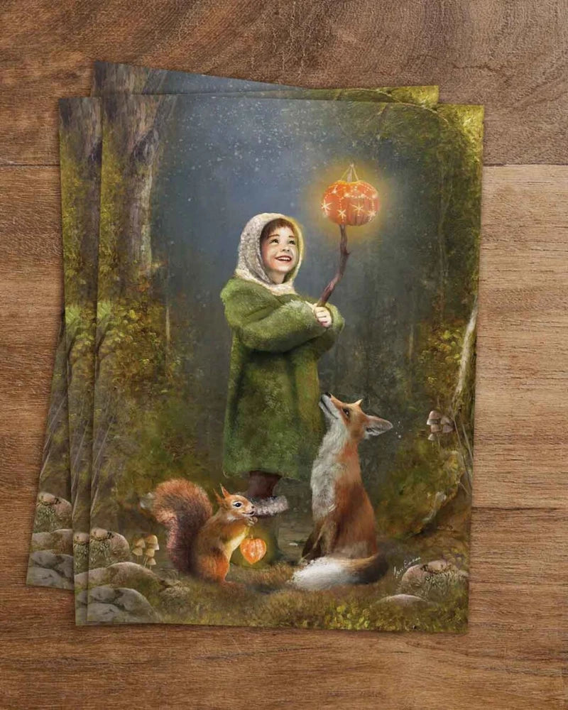 Postkarte Kürbisglühen von Iris Esther A6: ein Kind trägt in der Abenddämmerung eine leuchtende Kürbislaterne durch den Wald, ein Fuchs und ein Eichhörnchen begleiten es