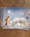 Postkarte Nikolausmädchen von Iris Esther A6: ein als Nikolaus verkleidetes Mädchen versorgt im verschneiten Dorf sein Pony und seinen Hund