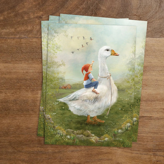 Postkarte Nils Holgersson auf der Wiese von Iris Esther A6: ein kleiner Junge sitzt auf dem Rücken einer großen weißen Gans auf einer Wiese