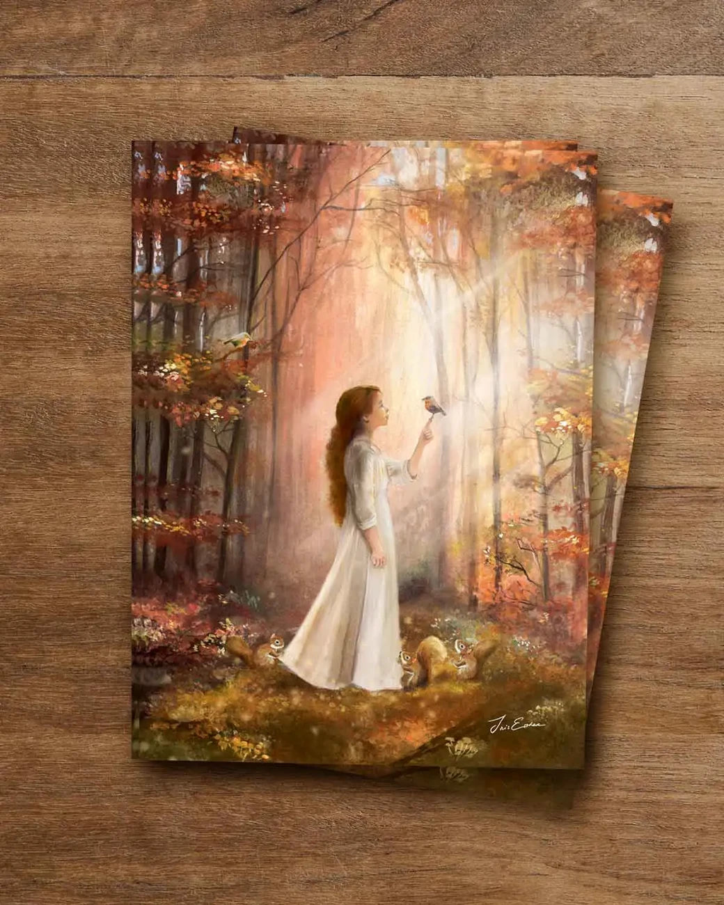 Postkarte Waldgeflüster von Iris Esther A6: eine junge Frau geht im frühen Herbstmorgen in den Wald, ein Rotkehlchen sitzt auf ihrem Finger