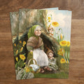 Postkarte Wurzelkinderfamilie von Iris Esther A6: Mutter Erde sitzt mit einem Korb an ihrer Baumhöhle, die Wurzelkinder nähen Frühlingskleider und schauen hervor