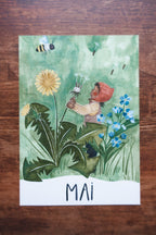 Monatskarte Mai aus dem Set von Joringl, Wichtel mit Pusteblume zwischen Löwenzahn, auf Holz fotografiert