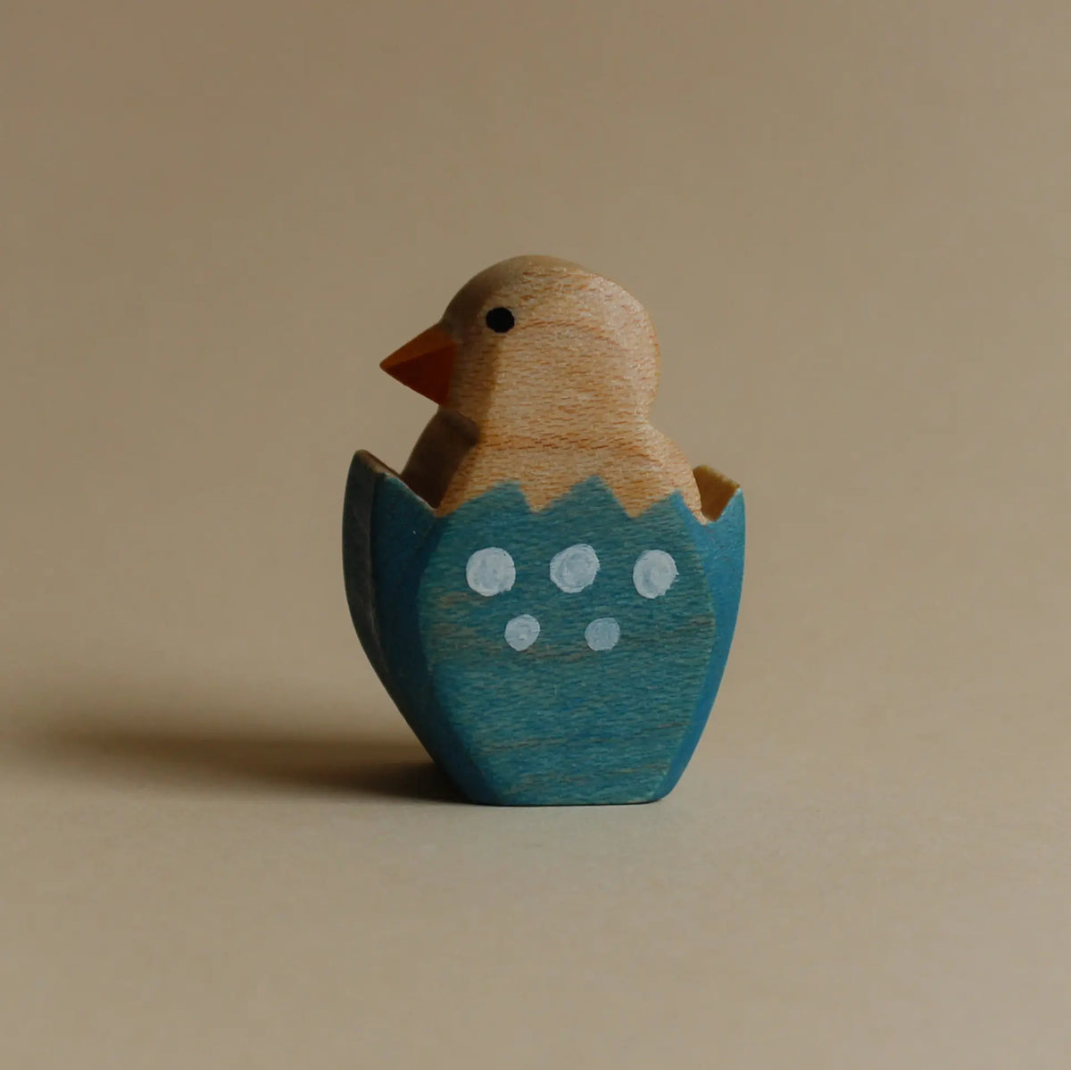 Juharka Holzfigur Küken im blauen Ei aus Ahornholz, Küken mit orangem Schnabel in blauer Eierschale mit weißen Punkten