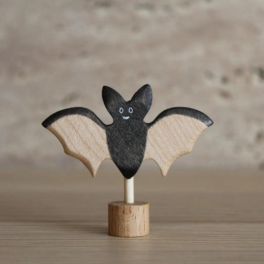 Juharka Stecker Fledermaus aus Ahornholz, lächelnde schwarze Fledermaus mit hellen Holzflügeln auf Holzfuß