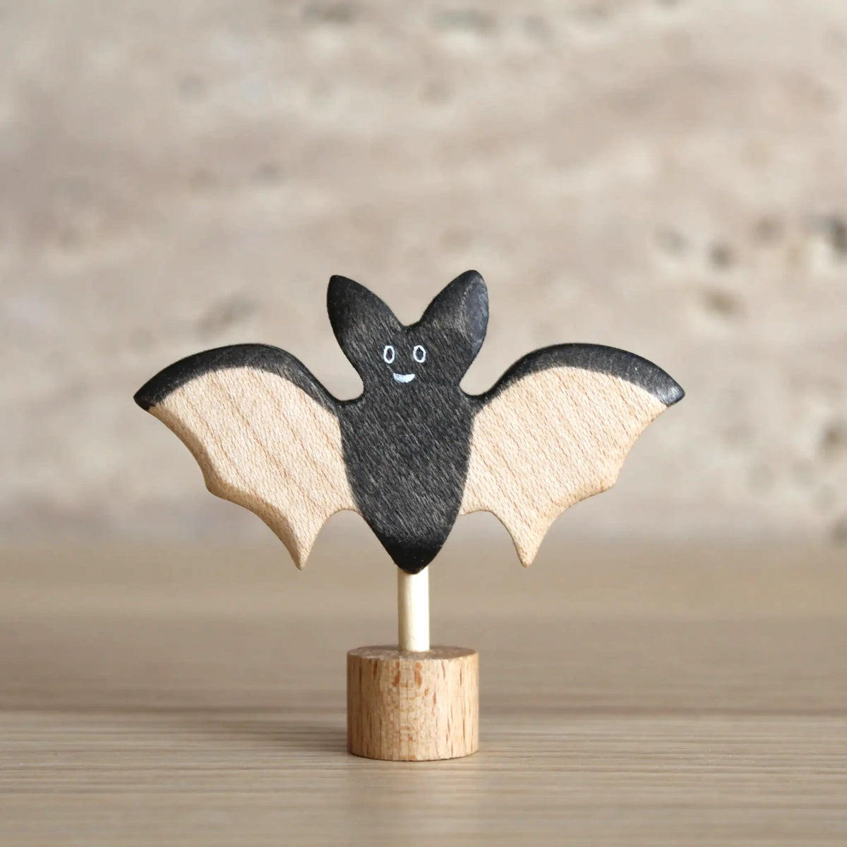 Steckfigur Fledermaus von Juharka aus Ahornholz, lächelnde schwarze Fledermaus mit hellen Holzflügeln auf Holzfuß