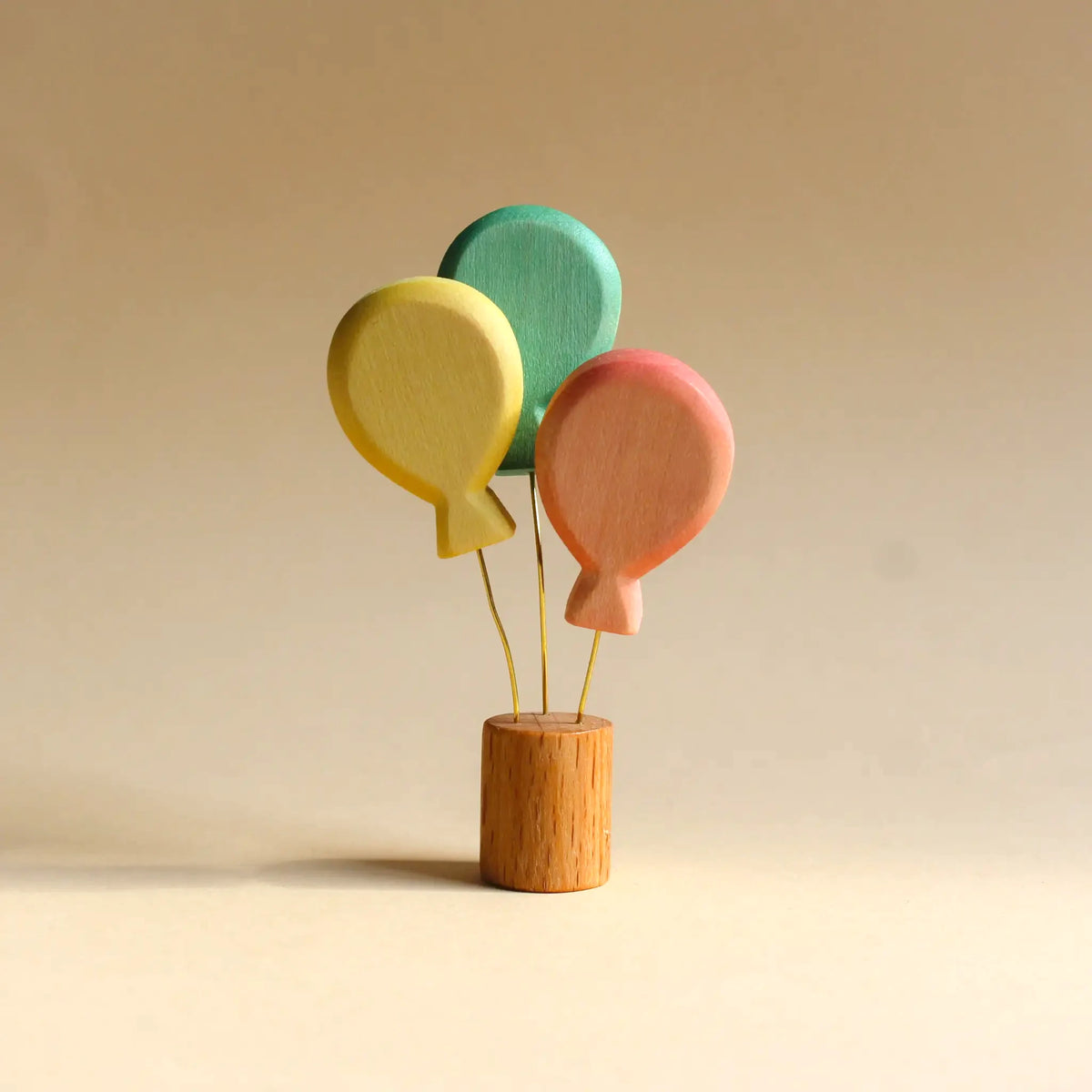 Steckfigur Luftballons von Juharka aus Ahornholz, drei Ballons in Gelb, Grün und Rosa an goldenen Drähten auf Holzfuß