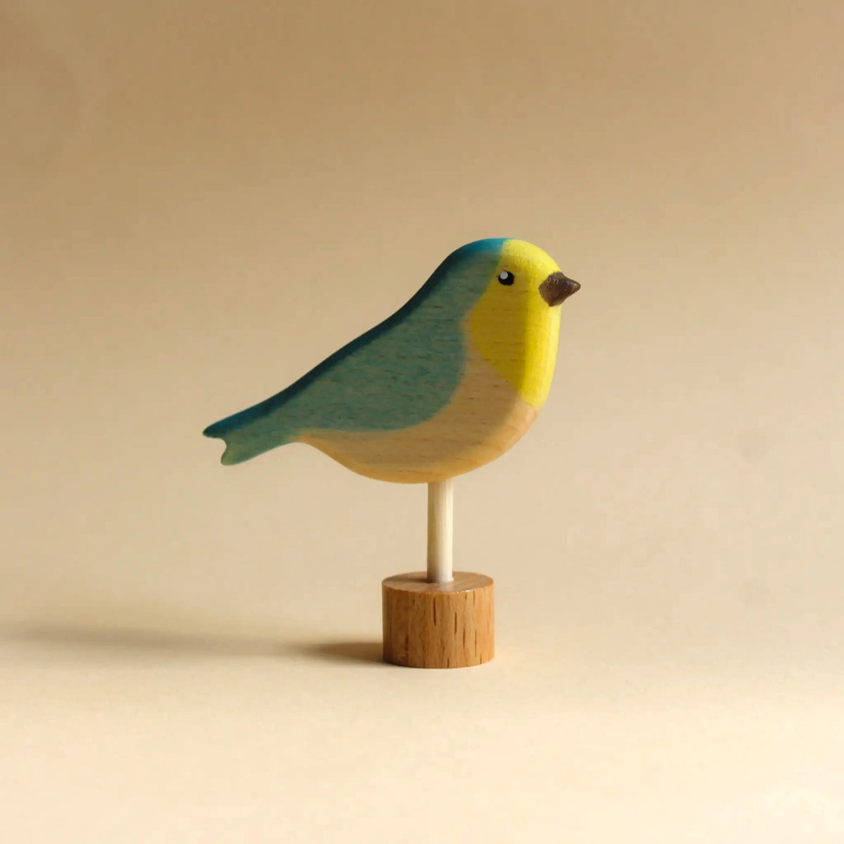 Steckfigur Vogel von Juharka aus Ahornholz, Vogel mit türkisblauem Rücken und gelbem Kopf auf Holzstab und Holzfuß