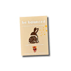 Emaille-Pin Hase be balanced von Esther Bennink, Emaille-Pin Hase auf einer hellen Karte mit dem Spruch be balanced
