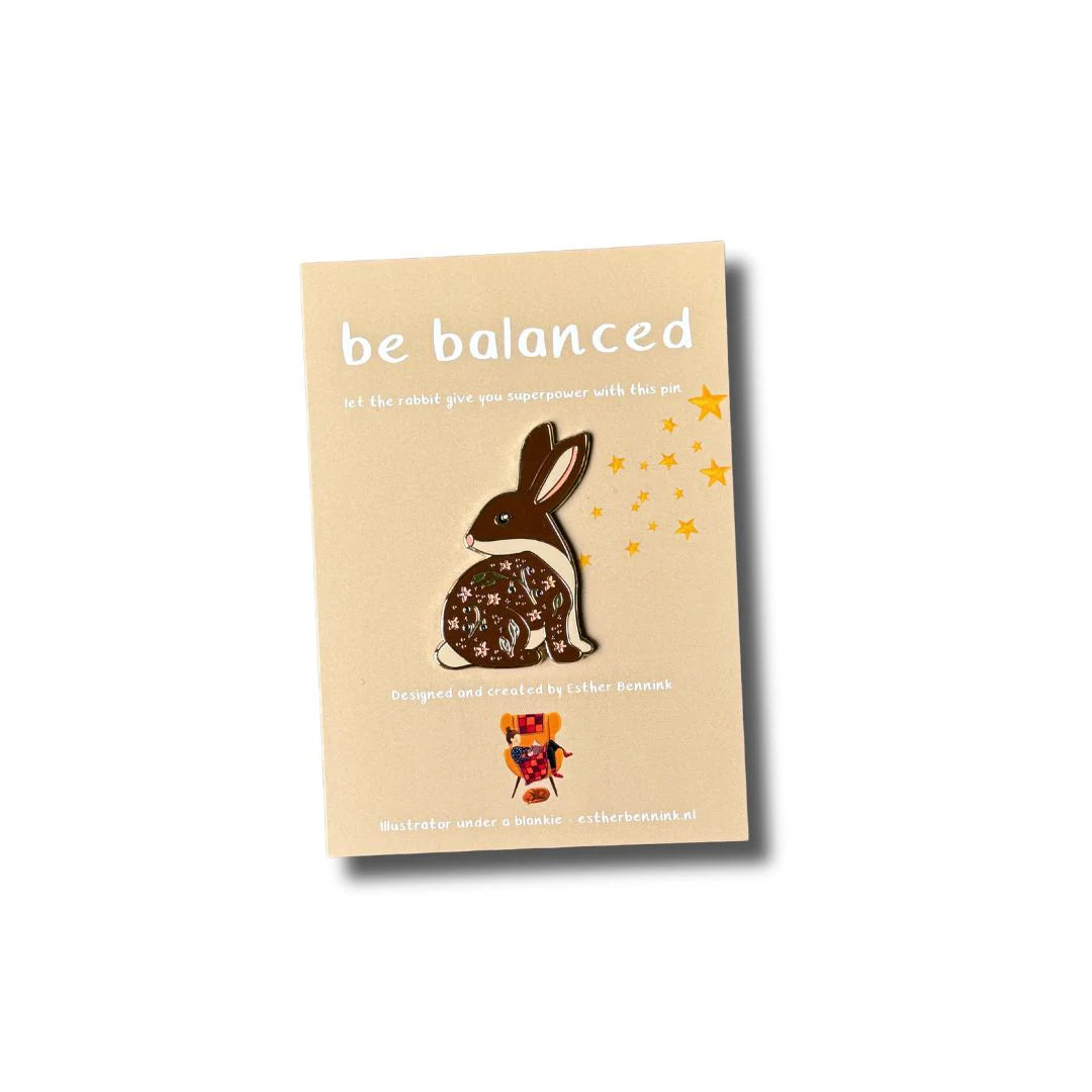 Emaille-Pin Hase be balanced von Esther Bennink, Emaille-Pin Hase auf einer hellen Karte mit dem Spruch be balanced