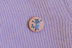 Button Waschbär von Liesels Wicht an einem lila Strickpullover angesteckt