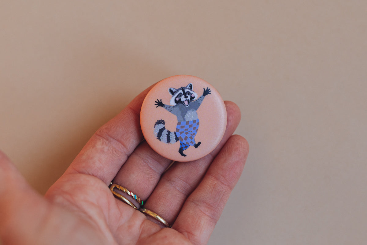Button Waschbär von Liesels Wicht in der Hand, hellrosa Button mit Waschbär