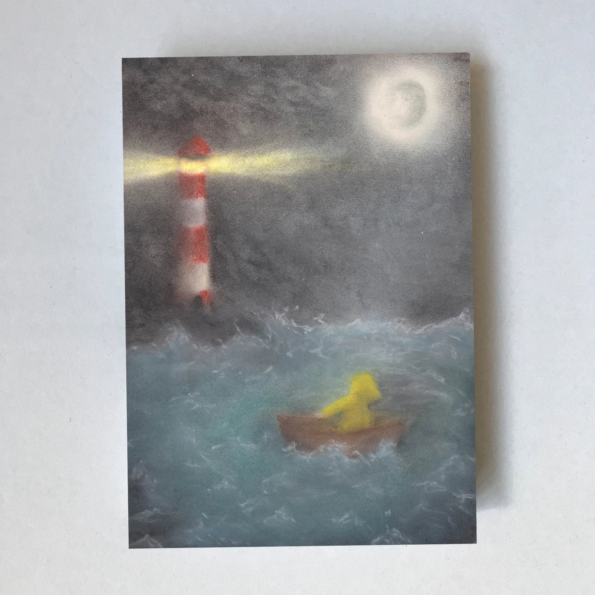 Postkarte Boot auf See von Lot Bouwes A6: rot-weißer Leuchtturm mit Lichtstrahl, Vollmond, kleines Boot mit einer Gestalt in gelbem Regenmantel auf bewegter See bei Nacht