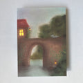 Postkarte Brücke von Lot Bouwes A6: steinerne Bogenbrücke über einen Fluss, ein rotes Haus mit Licht, ein kleines Tier auf der Brücke, kleines Licht am Ufer