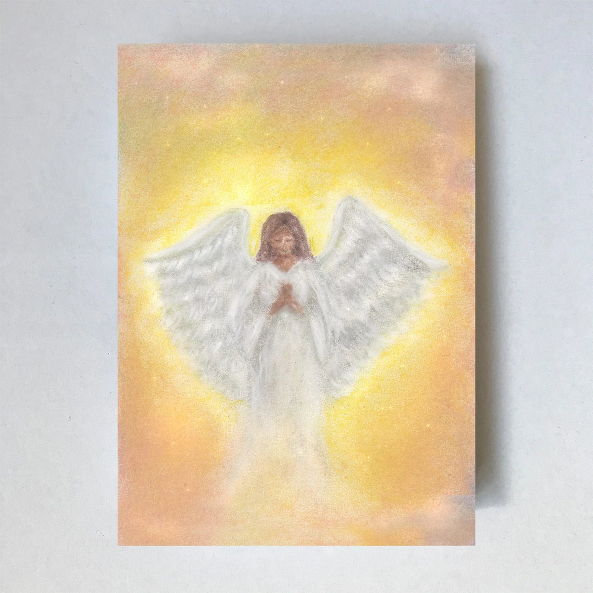 Postkarte Engel von Lot Bouwes A6: ein Engel mit weiten weißen Flügeln in goldgelbem Licht
