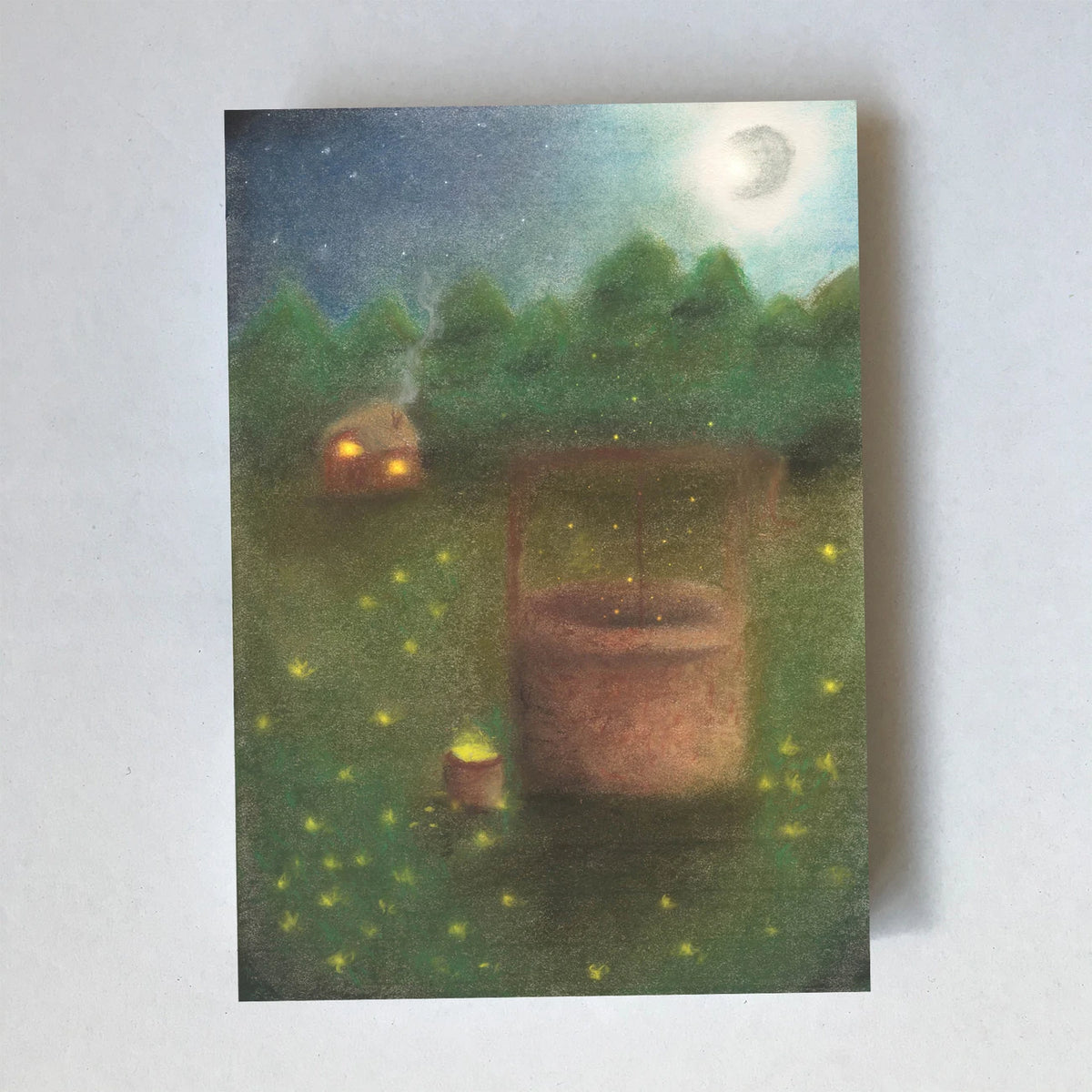 Postkarte Frau Holles Brunnen von Lot Bouwes A6: ein runder Steinbrunnen auf einer Wiese bei Nacht, Glühwürmchen, ein kleines Haus mit Licht, Mond