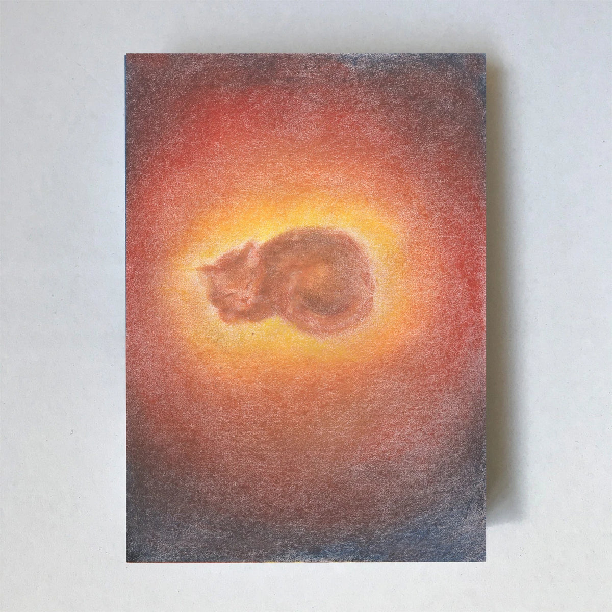 Postkarte Katze von Lot Bouwes A6: eine Katze schläft zusammengerollt in einem warmen, orange leuchtenden Lichtkreis