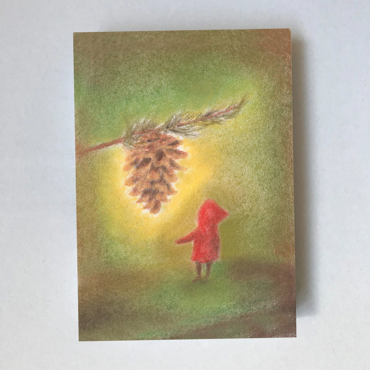 Postkarte Kiefernzapfen von Lot Bouwes A7: ein Wichtel steht unter einem großen Kiefernzapfen, der an einem Zweig hängt