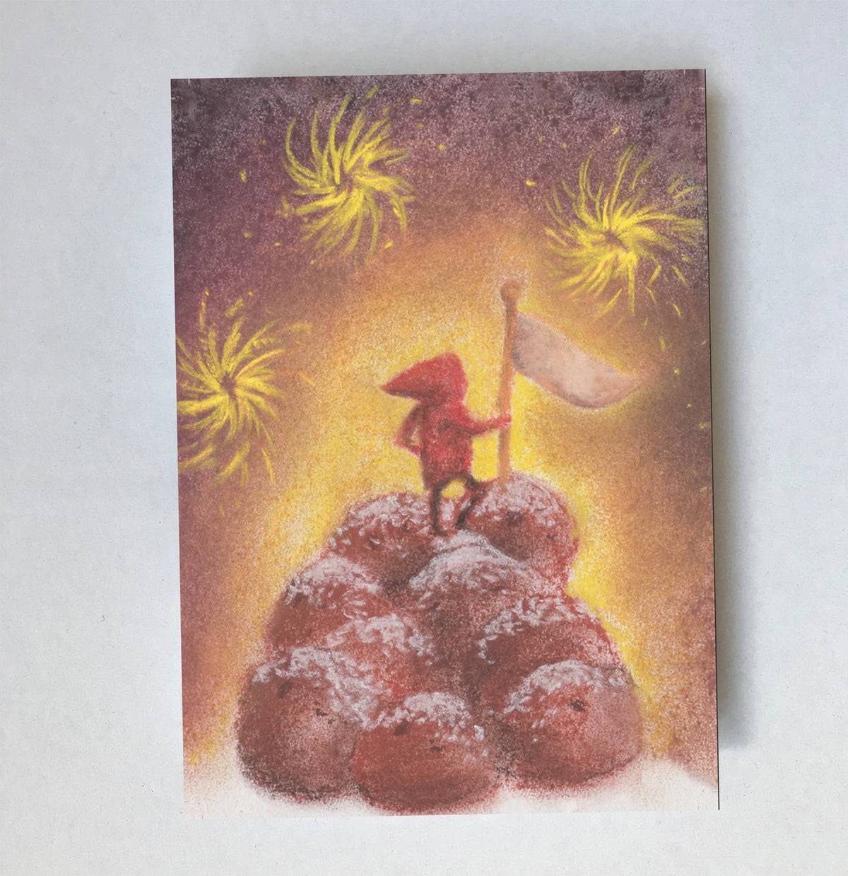 Postkarte Krapfen von Lot Bouwes A7: ein Wichtel steht mit einer Fahne auf einem Berg Krapfen, Feuerwerk am Himmel