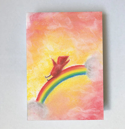 Postkarte Regenbogenrutsche von Lot Bouwes A7: ein Wichtel rutscht einen Regenbogen hinunter, rosa Wolken