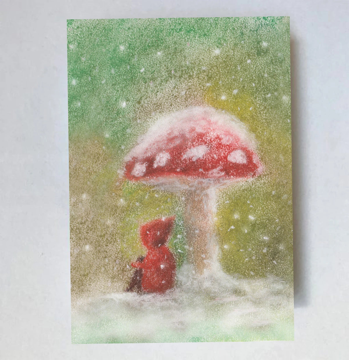 Postkarte Schnee von Lot Bouwes A7: ein Wichtel steht unter einem verschneiten Fliegenpilz, Schneeflocken fallen