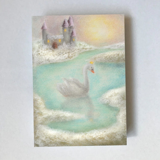 Postkarte Schwanenmeer von Lot Bouwes A6: ein weißer Schwan gleitet über einen türkisen See, im Hintergrund ein Schloss in den Wolken, goldene Sonne