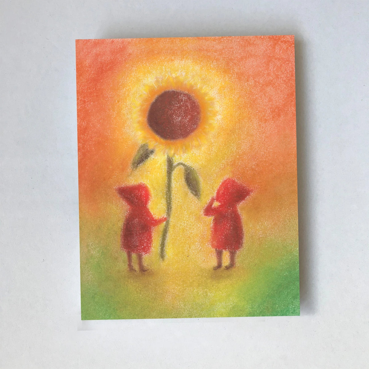 Postkarte Sonnenblume von Lot Bouwes A6: zwei Wichtel stehen unter einer großen Sonnenblume, oranger Himmel